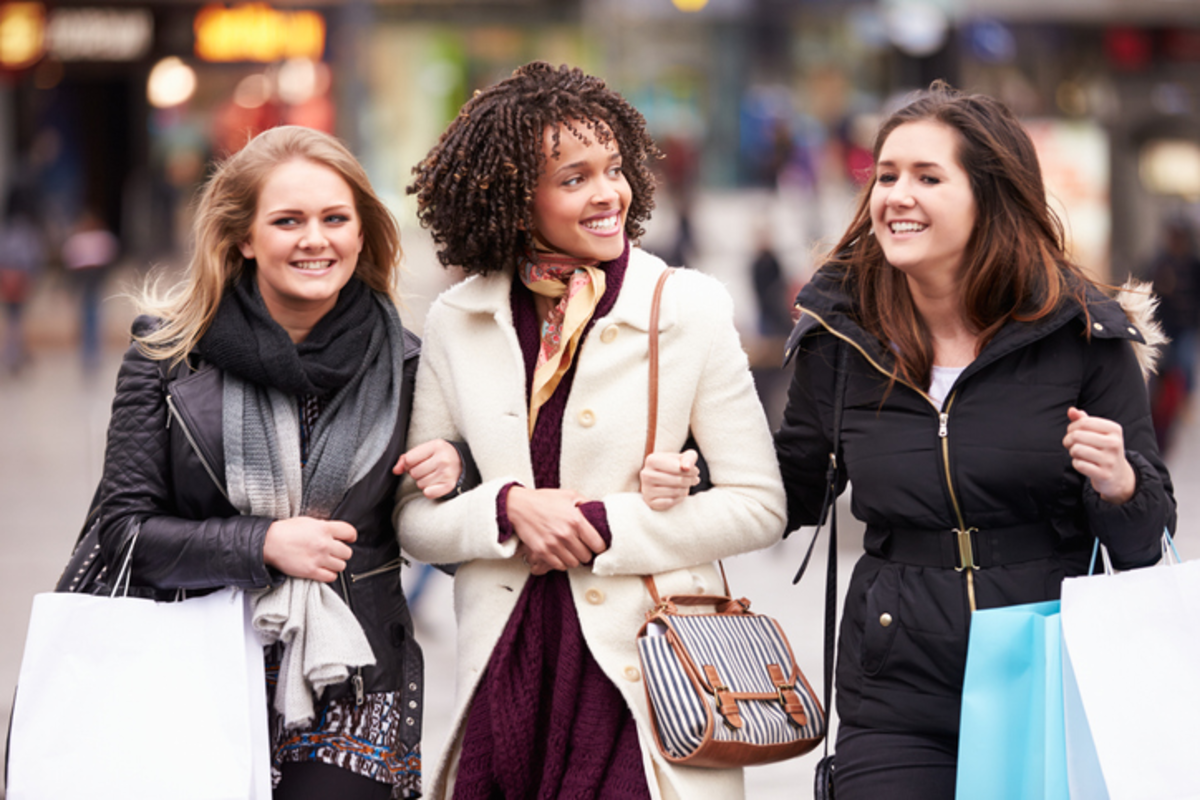 3 women shopping with linked arms