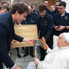 Pope Francis receives an axe from Jean-Baptiste Bonhoure, president of Ateliers Perrault, during an audience at the Vatican.