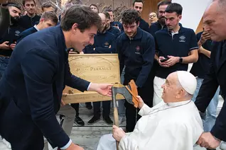Pope Francis receives an axe from Jean-Baptiste Bonhoure, president of Ateliers Perrault, during an audience at the Vatican.