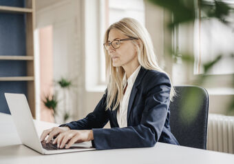 Woman working on a laptop with occupational glasses