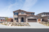 exterior of two-story home with desert landscaping and neutral paint