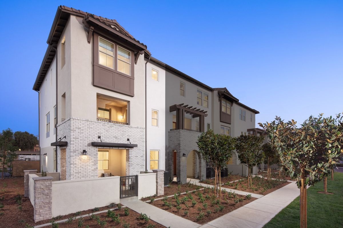 exterior of three-story townhome with large windows and neutral paint