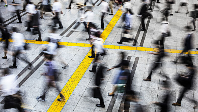 People in motion on sidewalk