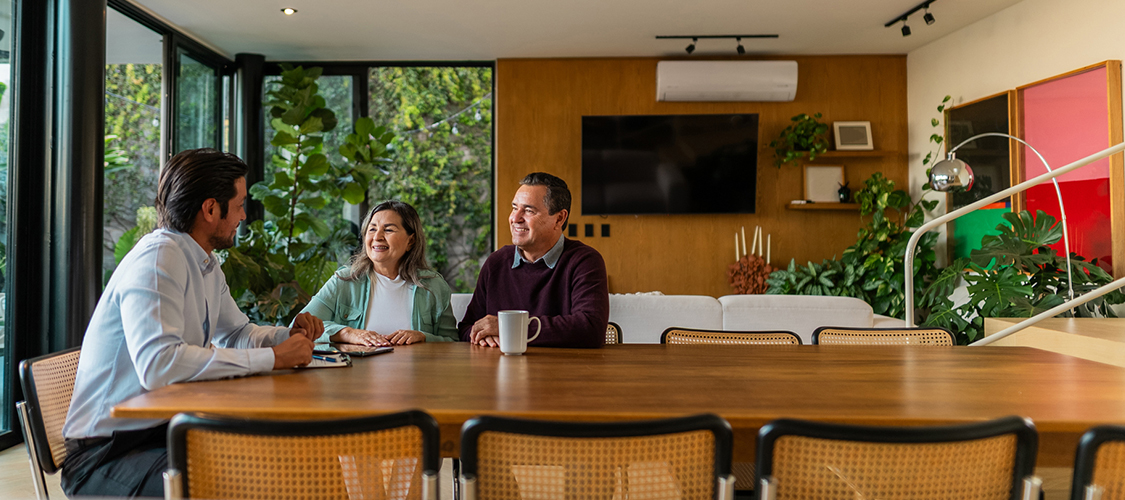 A couple sitting at a table next to a man.