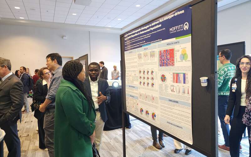 Poster presenters share their research with symposium attendees