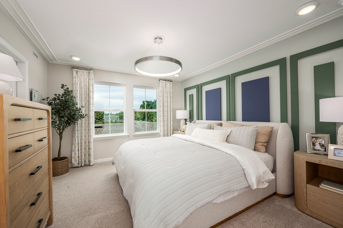 primary bedroom with white bed and carpet