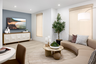 great room with tan crescent shaped sofa, round wood coffee table with potted succulents, and slate blue wall behind television