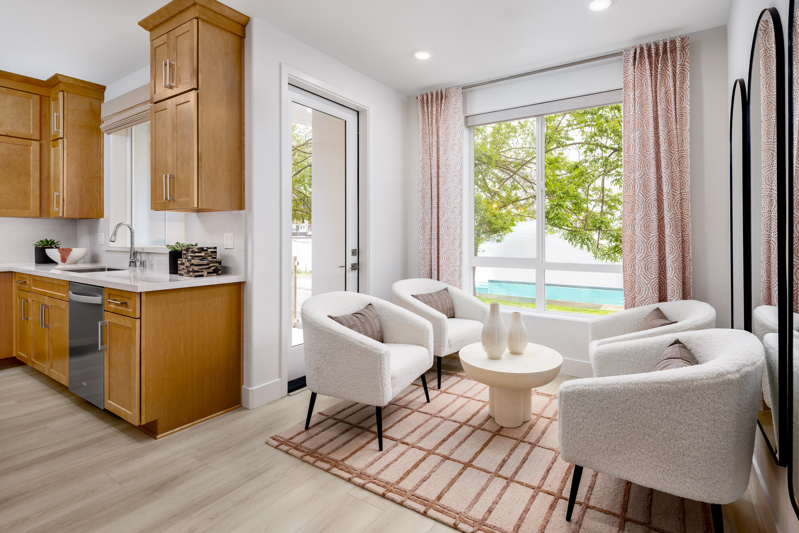 dining room with four white sherpa accent chairs, small white round coffee table, large window, and door leading to outdoor covered deck