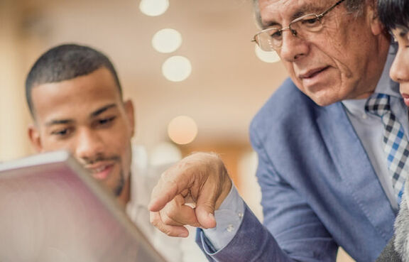 Senior business man giving younger colleagues advice