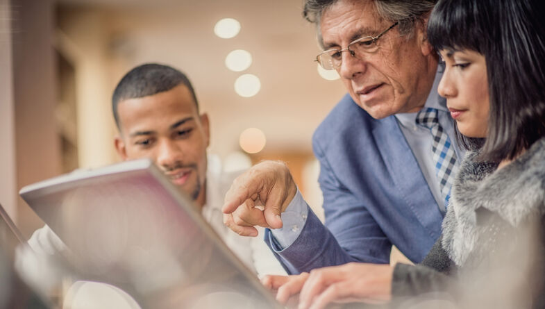 Senior business man giving younger colleagues advice