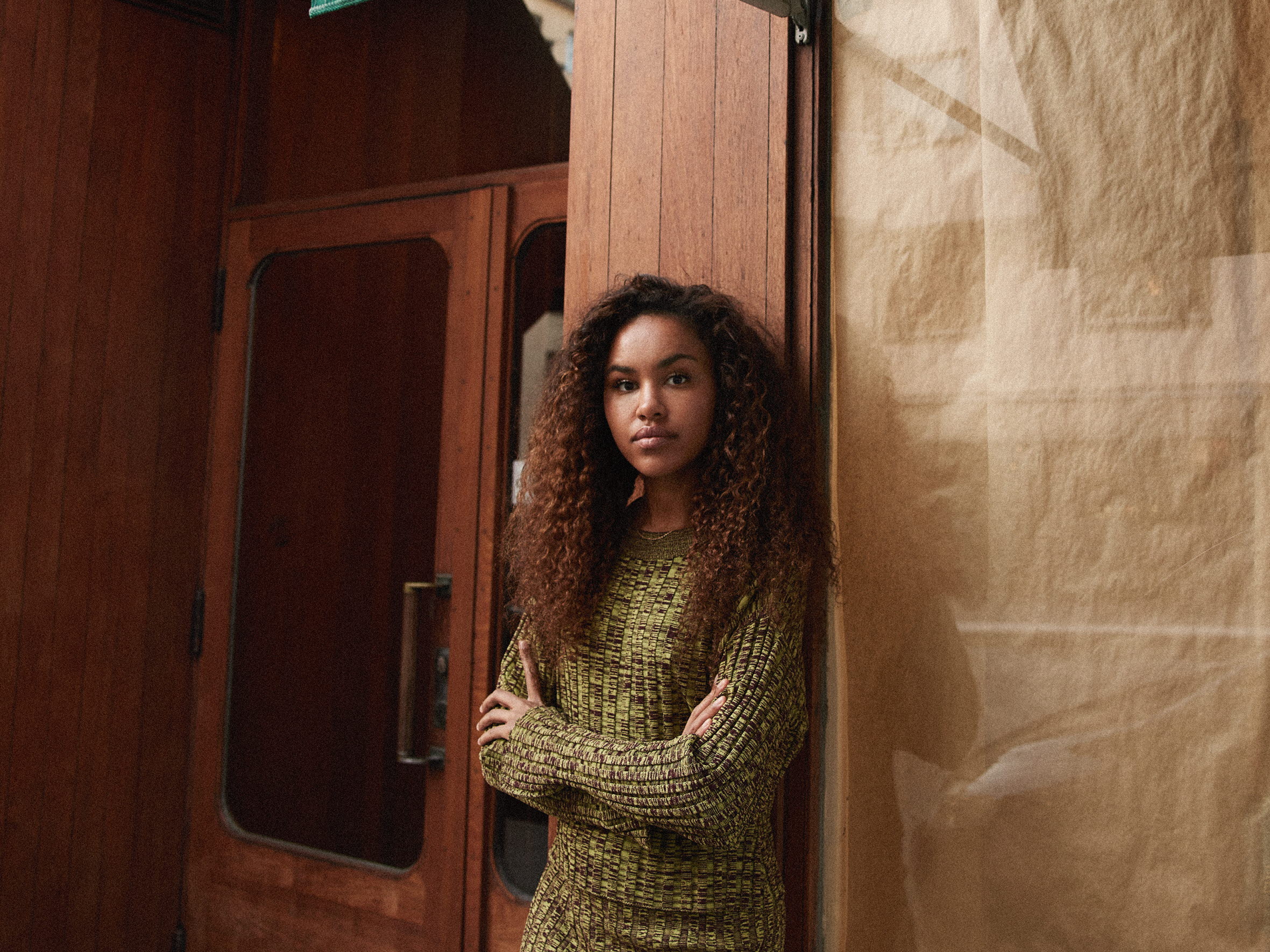 Ung kvinna står utanför porten till huset