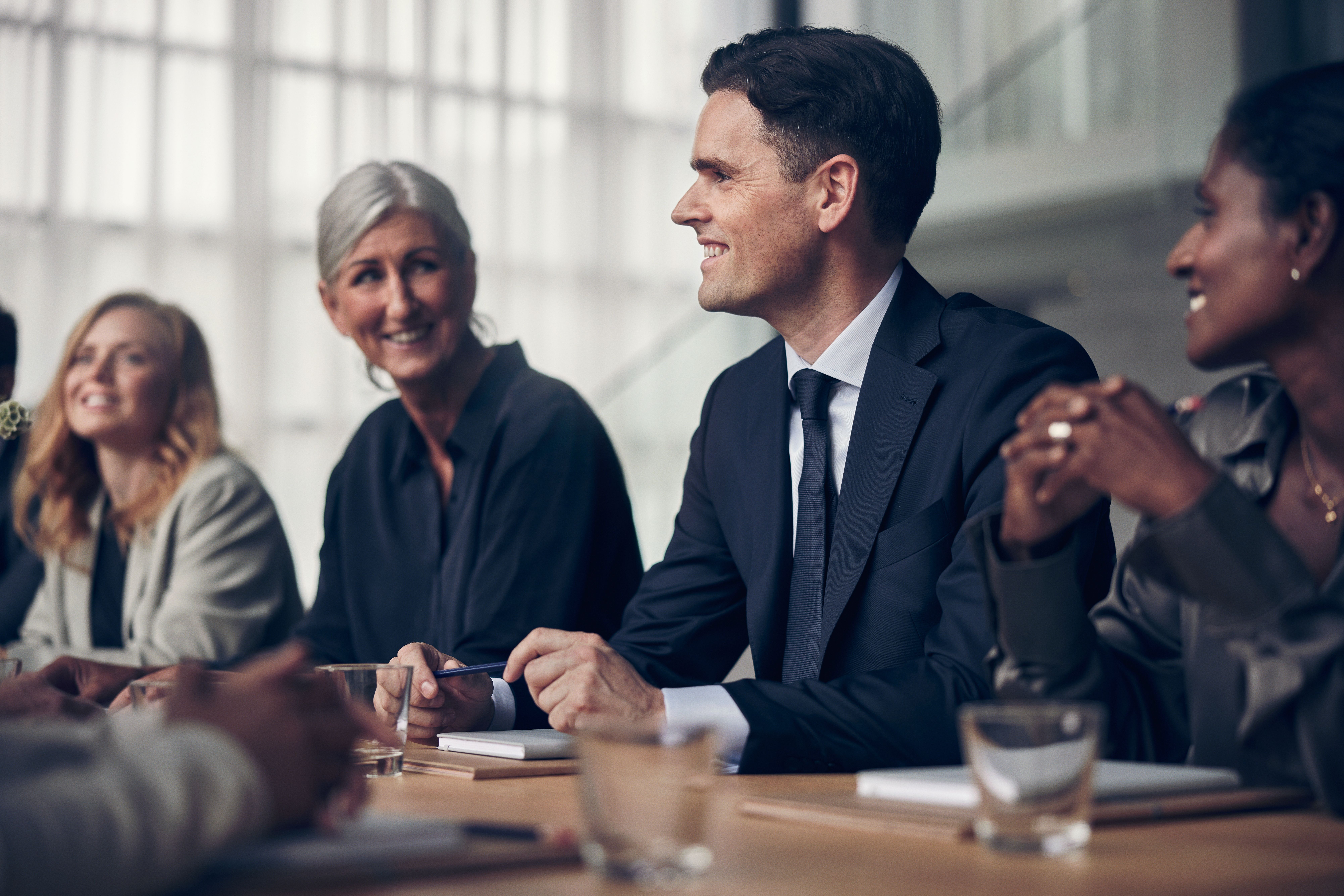 Mehrere Personen sitzen an einem Tisch und lächeln