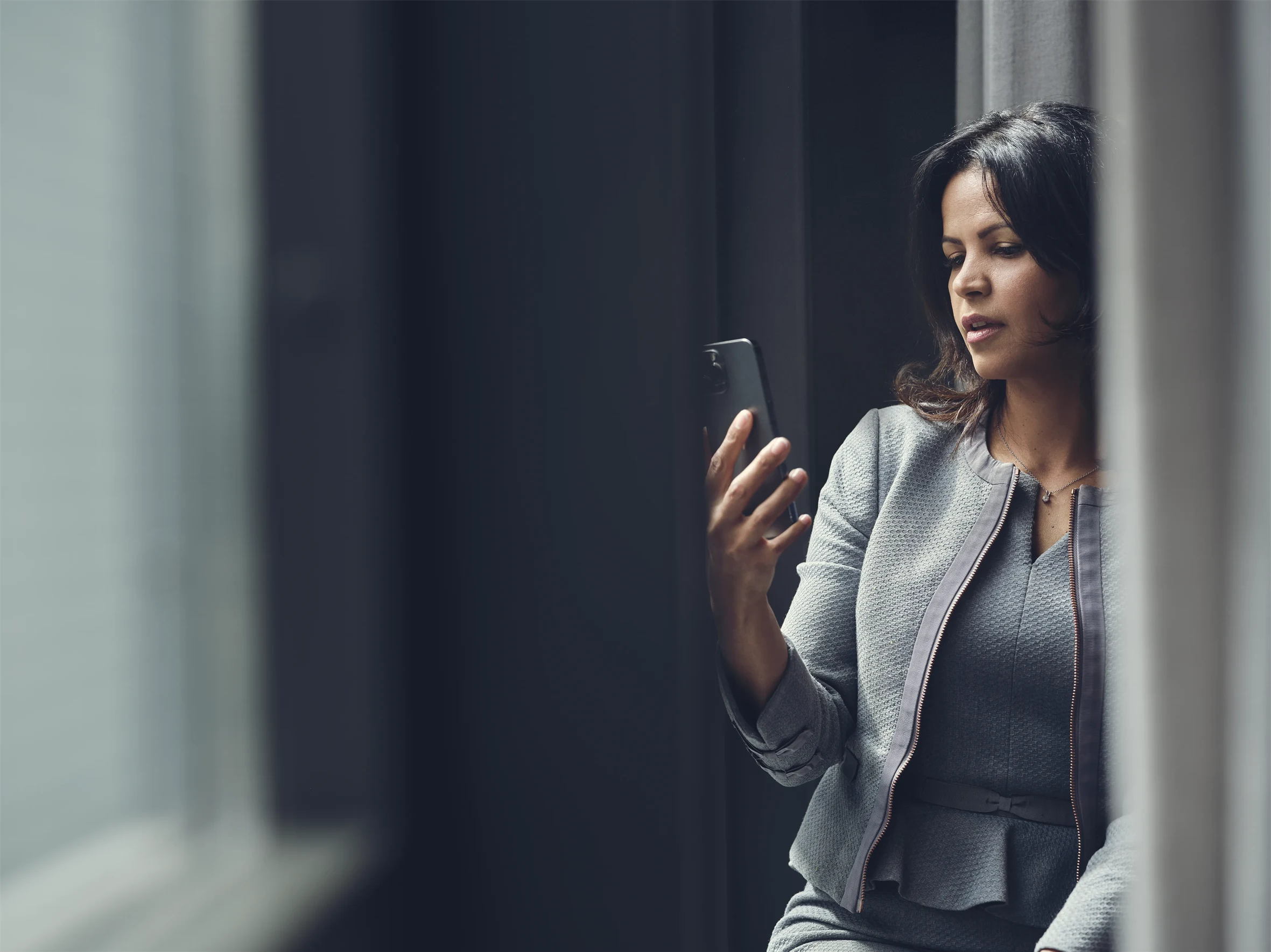 En kvinna som tittar i sin telefon.