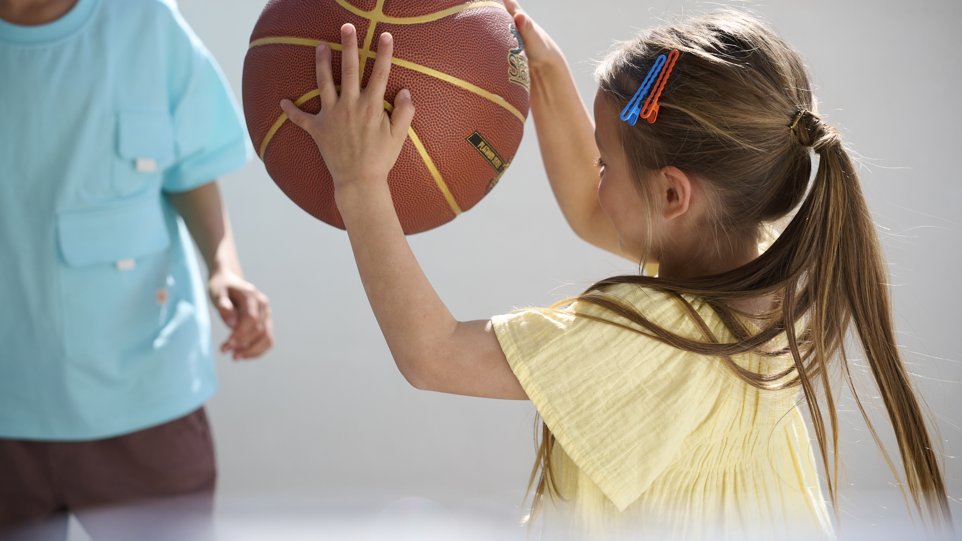 Two kids bouncing a ball