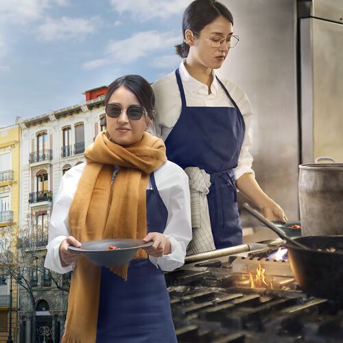 Un cocinero que usa lentes fotosensibles HOYA Sensity mientras trabaja tanto en interiores como en exteriores.