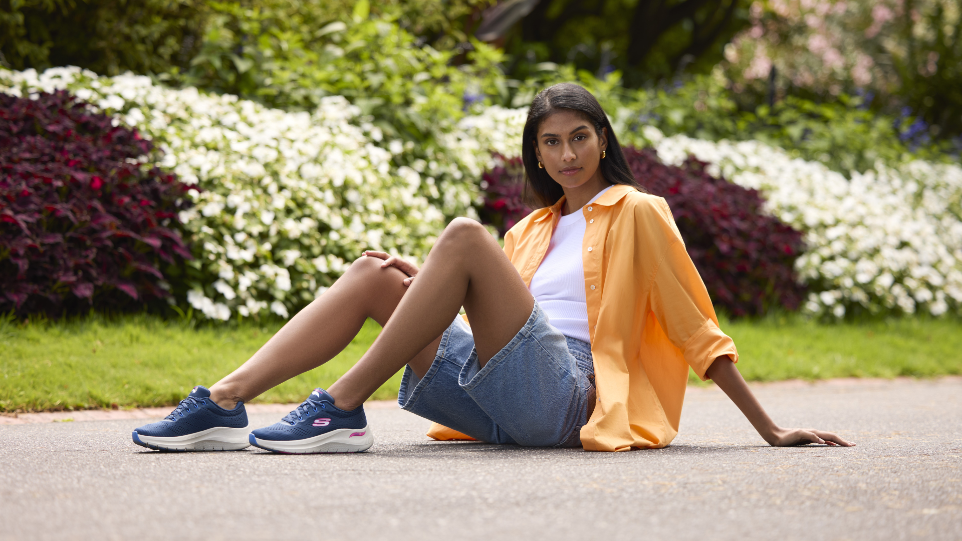 Woman sitting in a garden with her Skecher shoes on her feet