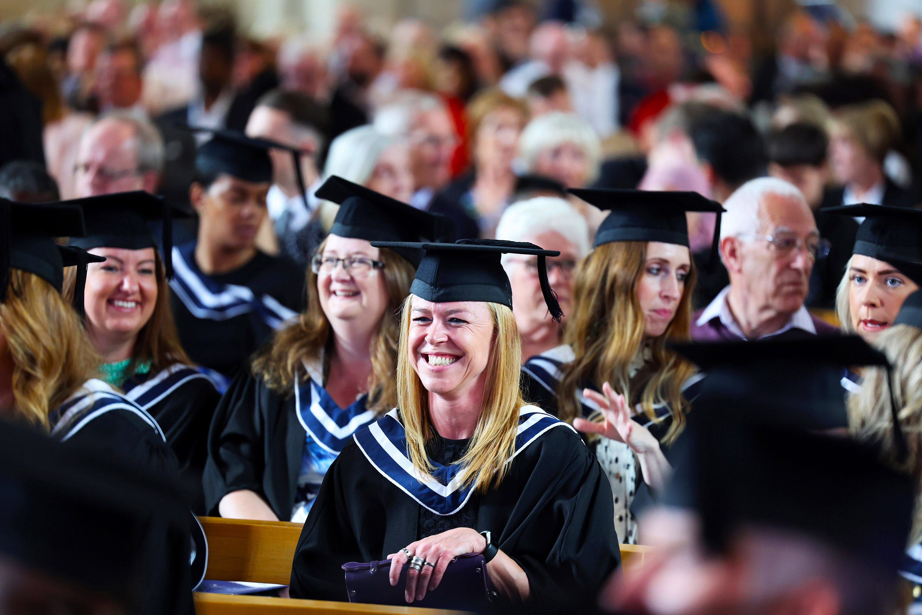 Smiling graduate in a crowd of students during the ceremony