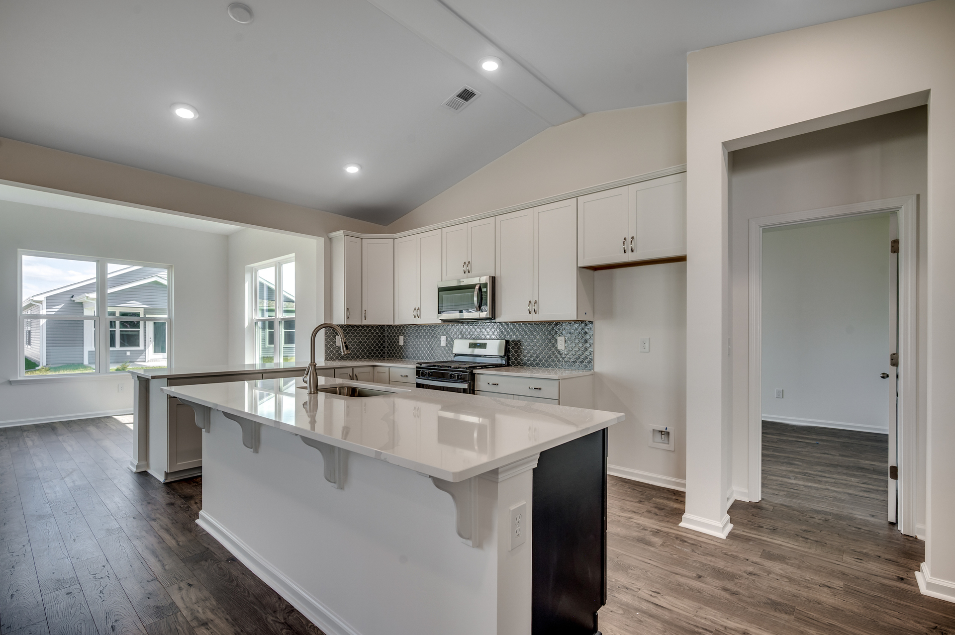 bright white cabinets with large island, bright white counter and backsplash