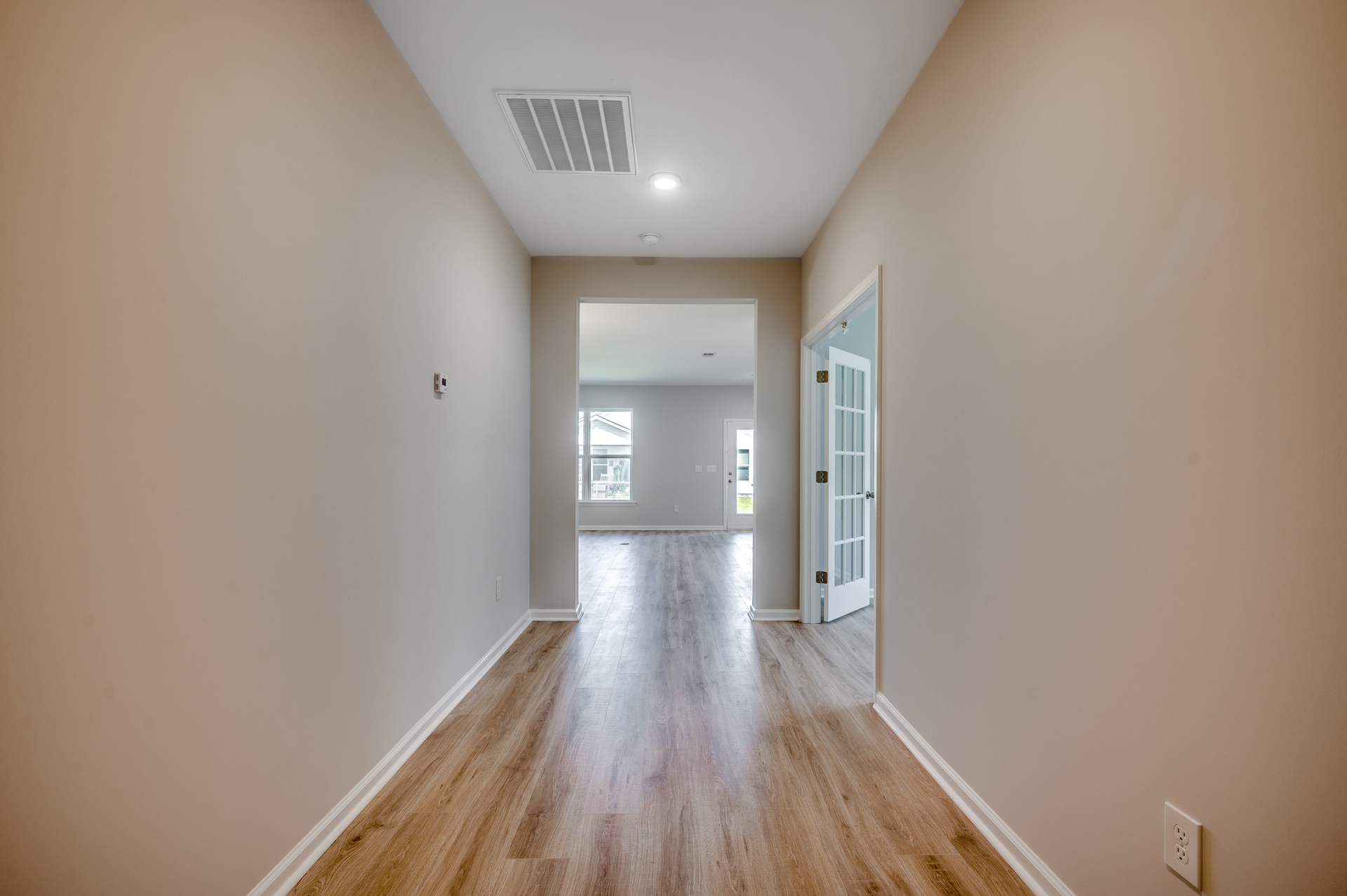 bright entryway with hardwood flooring and tan walls