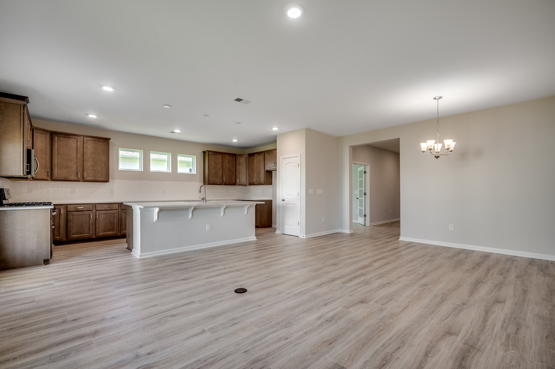 open-concept area with large kitchen island and hardwood flooring 
