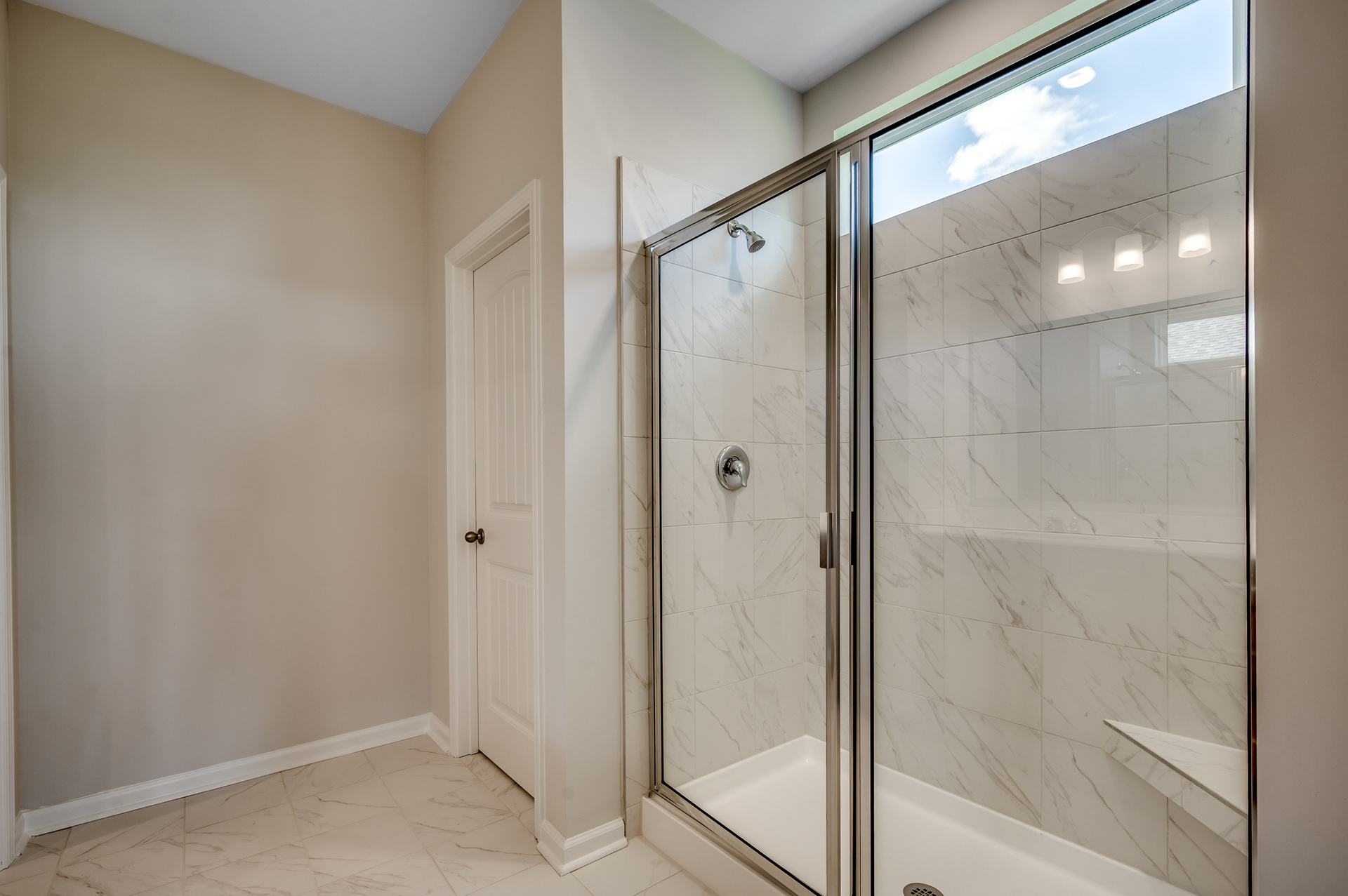 spacious walk-in tiled shower with glass door 