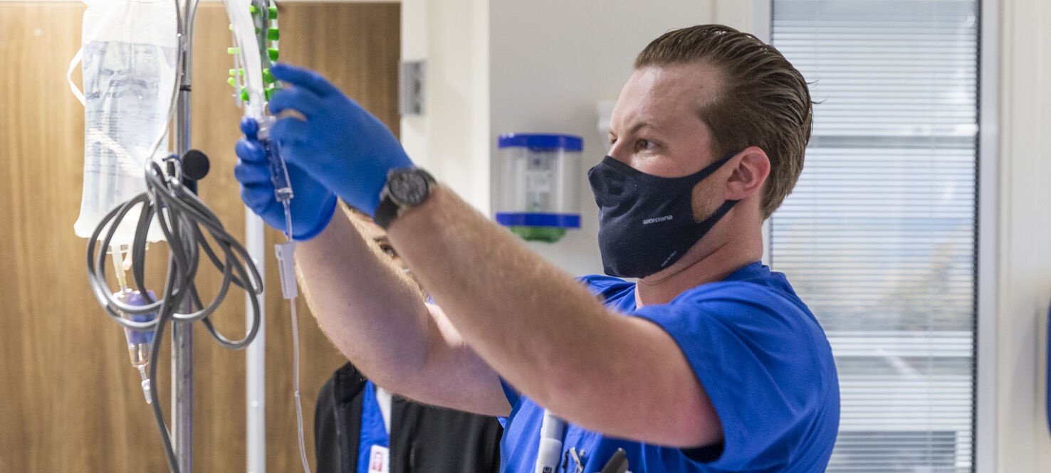 Nurse Ivan Ross hangs a bag of cells to begin a TIL infusion.