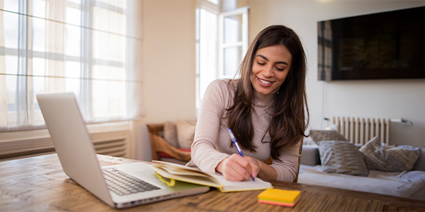 A woman smiling as she does paperwork.