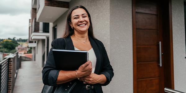 A smiling woman holding paperwork