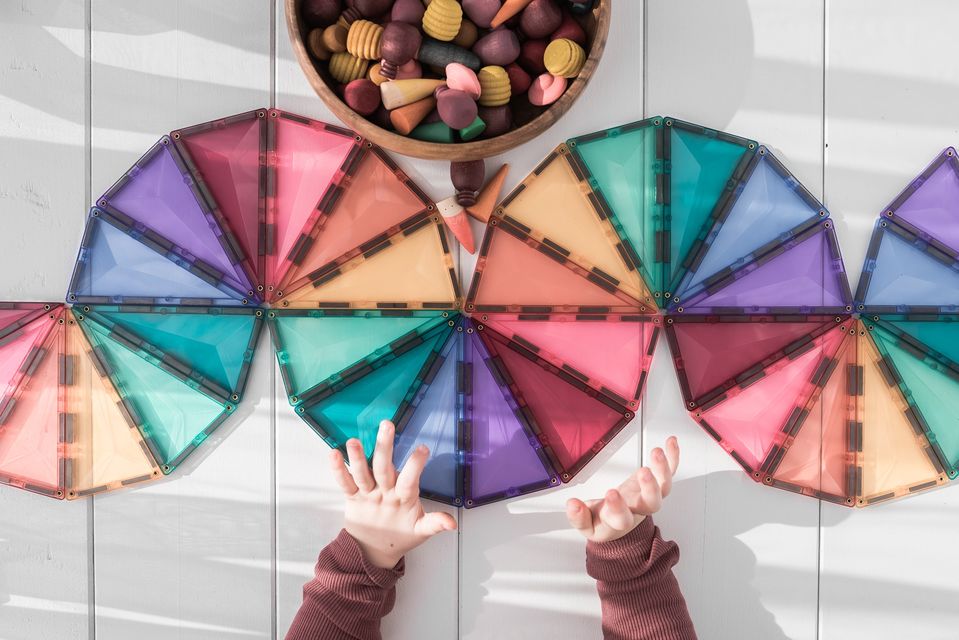 child hands playing magnet blocks