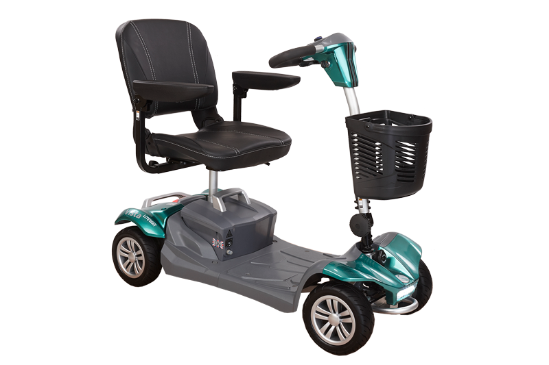 A compact mobility scooter with a black padded seat, armrests, and a small front basket. The scooter has four wheels, a grey base, and metallic teal panels on the front and rear. The tiller is slim and upright, with simple handlebar-style controls.