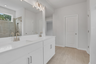 primary bathroom with white cabinets and tile flooring 