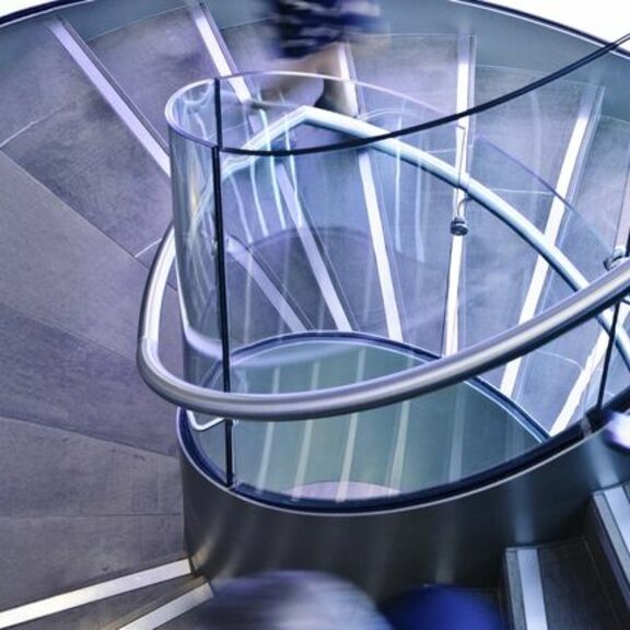 Person in motion walking down spiral staircase