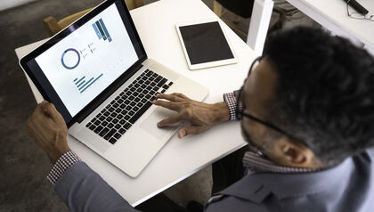 Man in suit using a laptop at a table