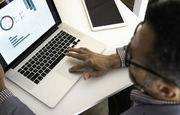 Man in suit using a laptop at a table