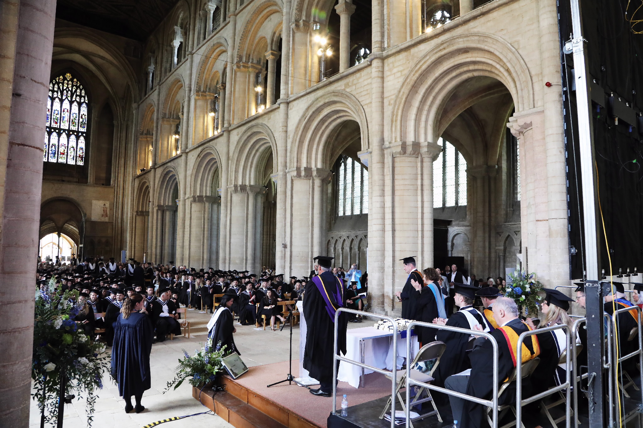 Wide view of the graduation ceremony taking place inside a grand cathedral
