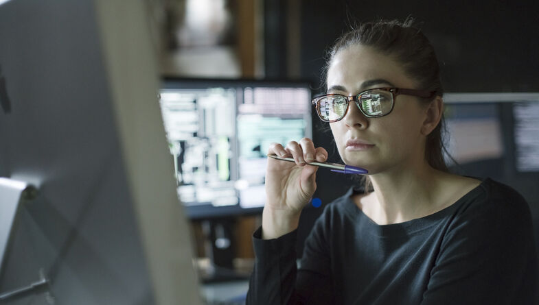 Woman working on computer in dark office