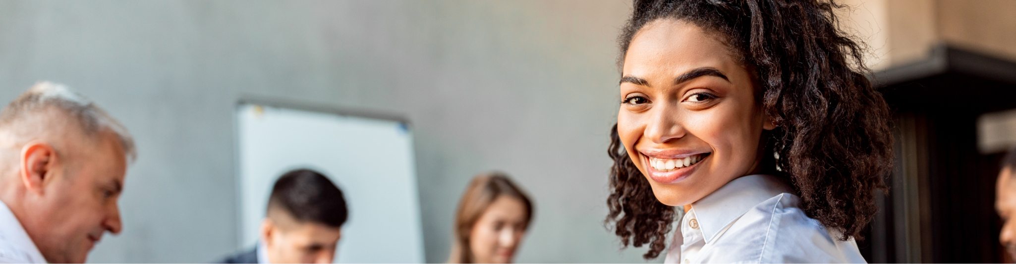Women smiling at camera in an office environment.