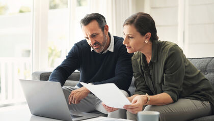 Man and woman discussing taxes over laptop