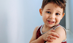 Deček po cepljenju junaško kaže obliž, ki prekriva mesto vboda.