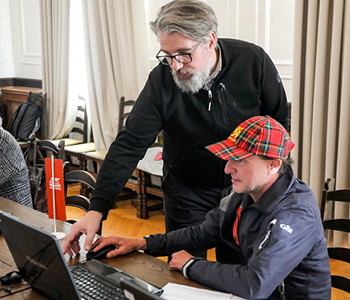 Prizor s tečaja Digitalno samostojni kjer učitelj tečajniku pomaga pri uporabi računalnika.