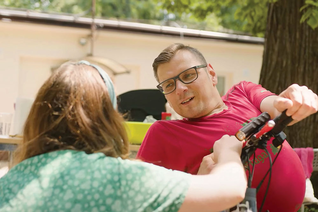 A Klika volunteer chats with a guest during a picnic