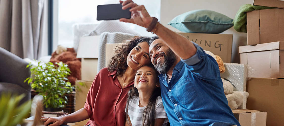 family taking a selfie sitting on the floor in their new home