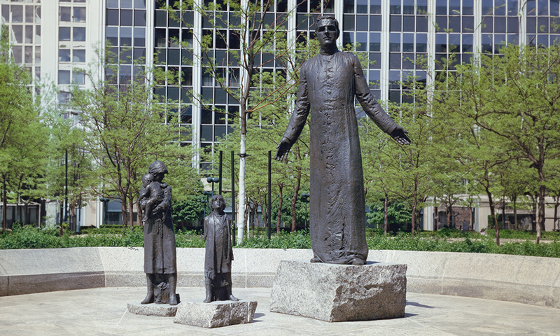 Two figures with Father McGivney tells the story of the founding of the Knights of Columbus.