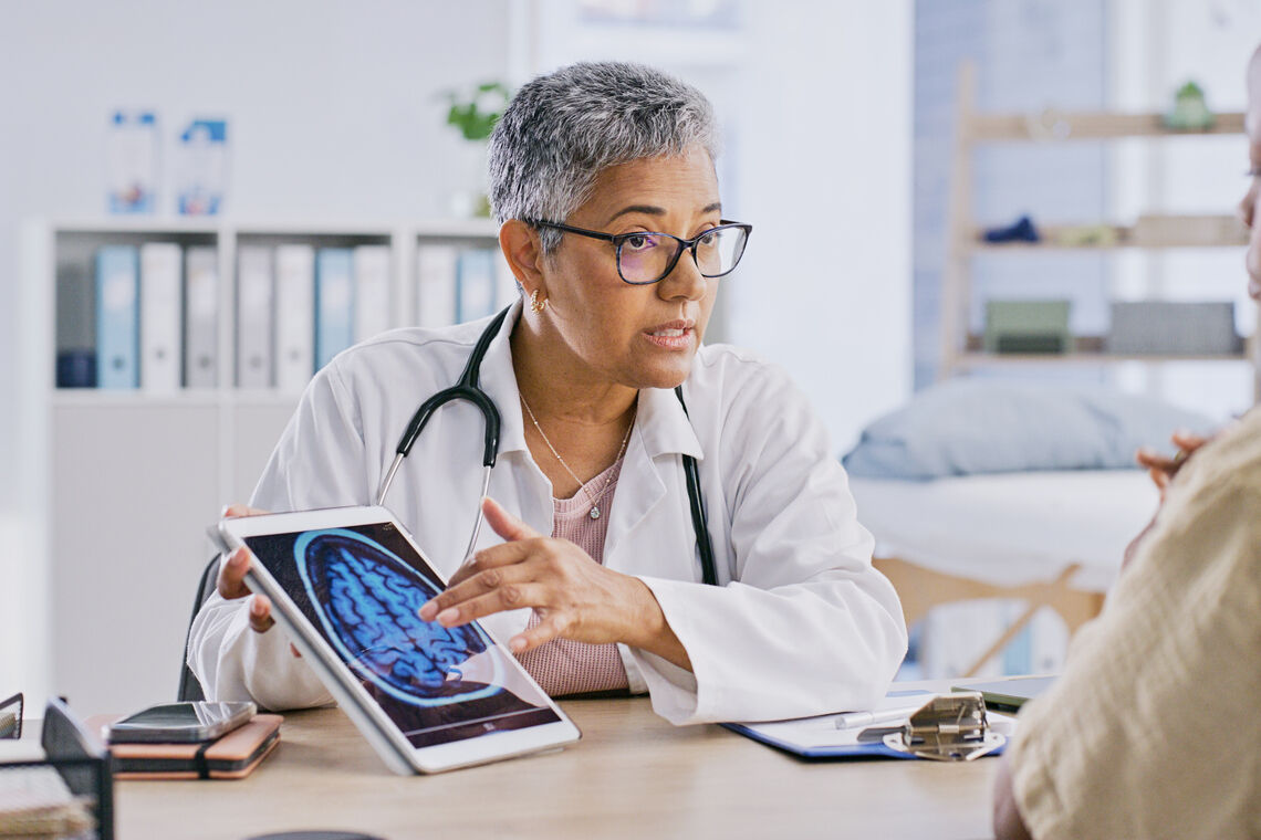 Doctor reviews brain scan with patient for low-grade glioma treatment