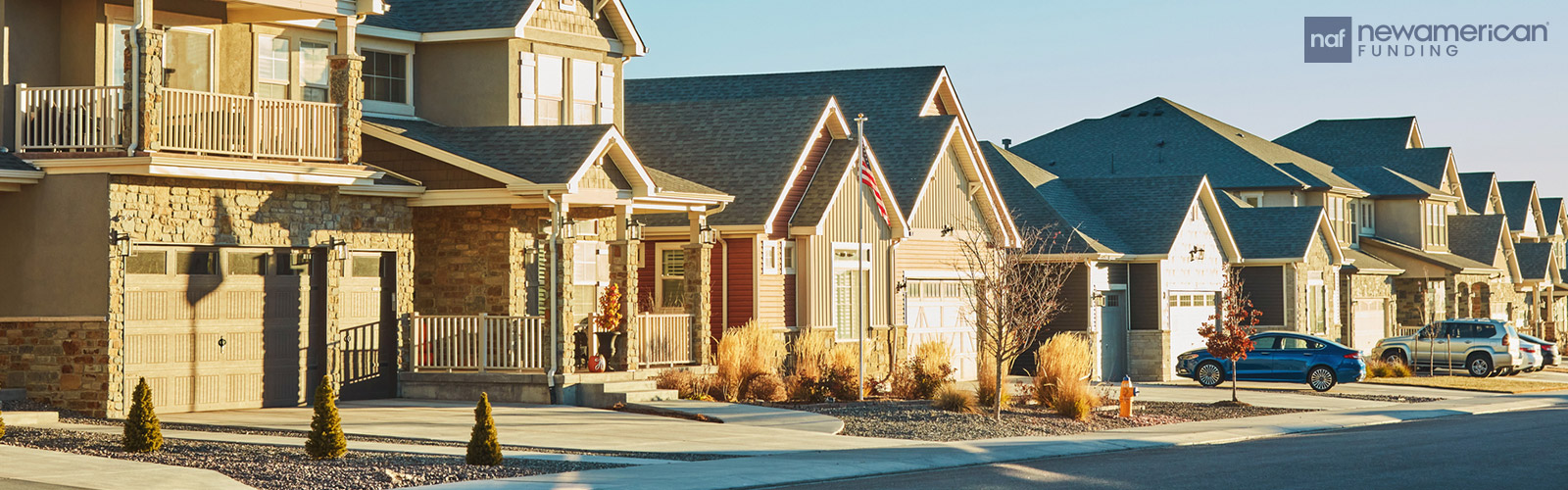 Row of neutral colored neighborhood homes made of brick and vinyl 