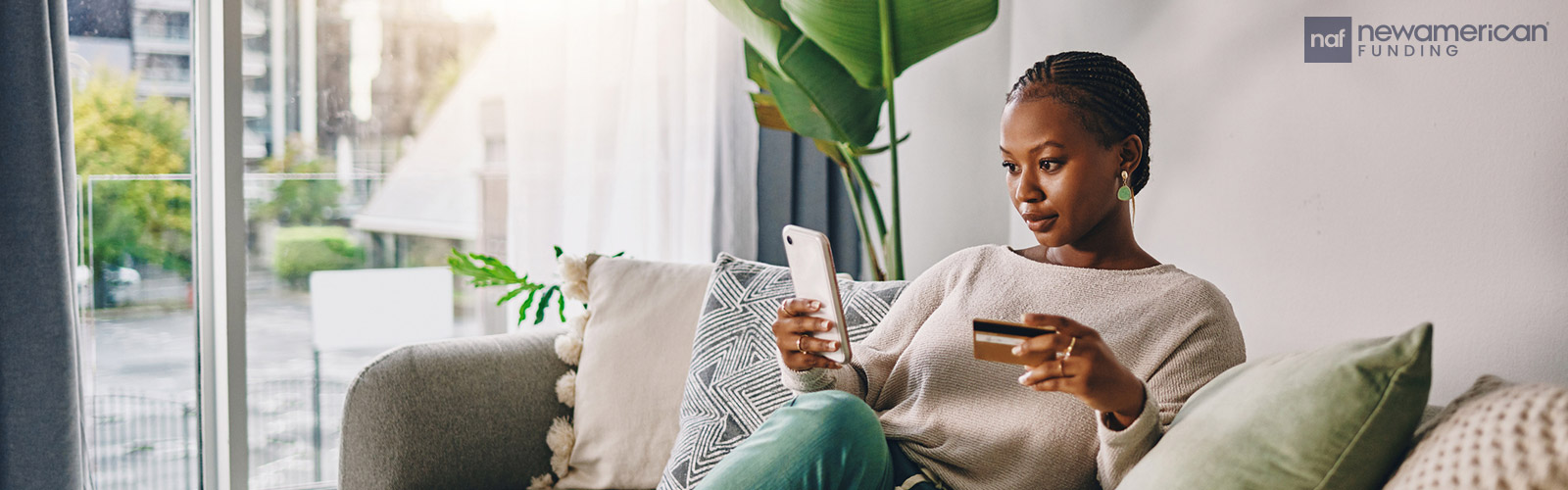 woman on her phone holding a credit card