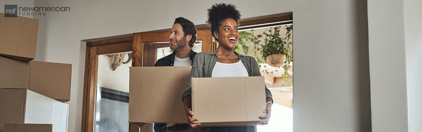 couple moving boxes into their new home