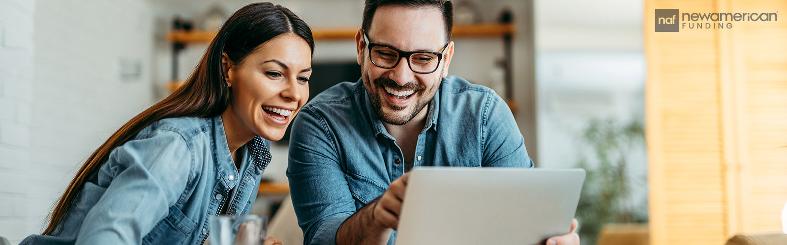 smiling couple looking at a laptop together