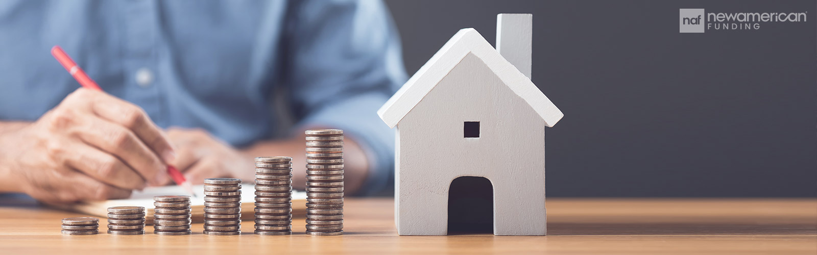 stacks of coins ascending higher towards the height of a house model