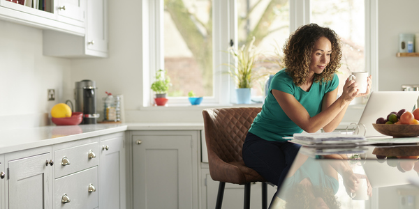 A woman sitting at her computer in her kitchen